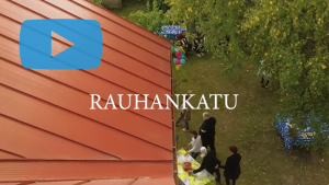 Ruutukaappaus videosta. Kuvassa pihajuhlat ja teksti: "Rauhankatu."