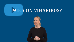 Ruutukaappaus videosta. Kuvassa nainen katsoo kameraan. Teksti: "Mikä on viharikos?"