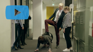 Ruutukaappaus videosta. Kuvassa neljä henkilöä kiusaamassa maassa makaavaa naista.