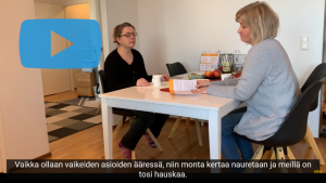 Ruutukaappaus videosta, jossa kaksi ihmistä keskustelee pöydän ääressä.