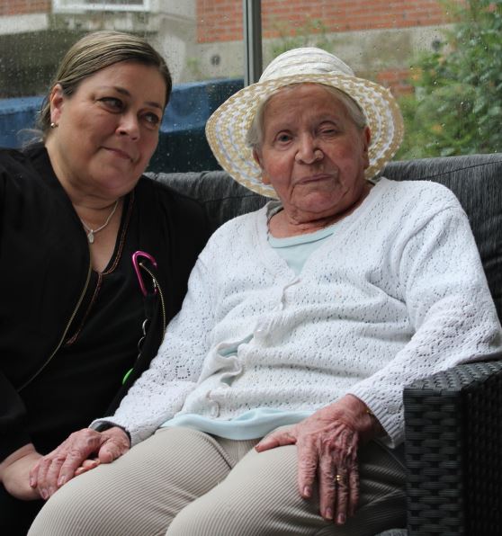 Aikuinen istumassa vanhuksen vieressä